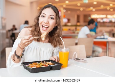 Asian Girl Eating Japanese Gyoza Dumplings In Food Court During Lunch Break