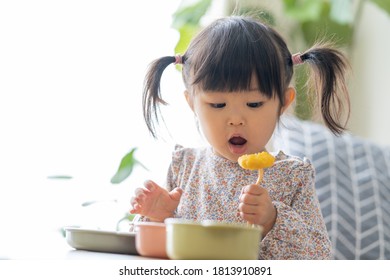 Asian Girl Eating In The Living Room