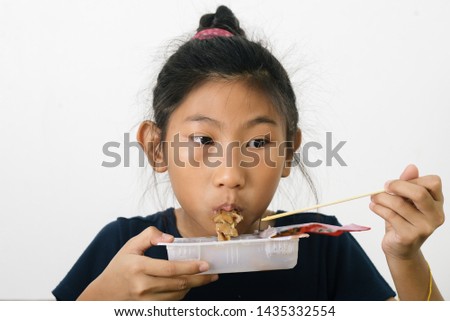 Asian girl eating spaghetti food box from convenient store, modern lifestyle concept.
