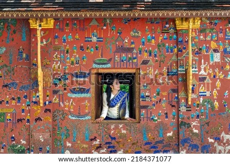 Asian girl enjoy travel in Wat Xieng Thong temple one of the most famous attraction place in Luang Prabang, Laos.