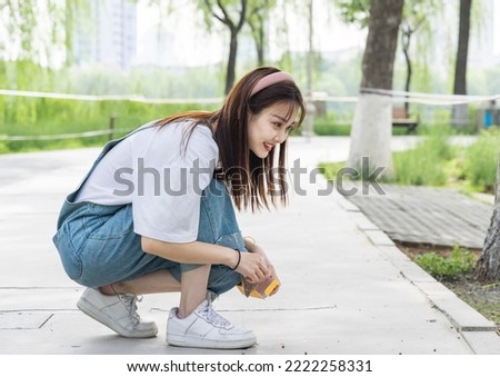 Asian girl feeding ducks in the park