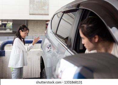 Asian girl help waving a car for her mother to reverse in parking car,her mother drove carefully - Shutterstock ID 1331868131