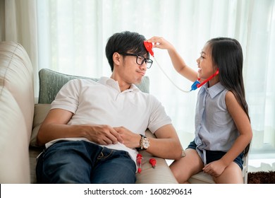 Asian Girl And Her Father Play Togather For Doctor Job And Medical Toy In Living Room, This Image Can Use For Dream, Education, Kid And Health ConceptA