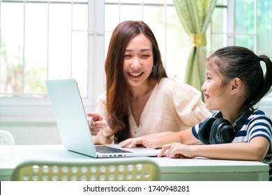 Asian girl and her teacher using laptop for online study during homeschooling at home. homeschooling, online study, new normal, online learning, corona virus or education technology concept - Powered by Shutterstock