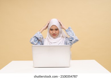 Asian Girl In Hijab Working Online, Sitting In Front Of Laptop During COVID-19 Pandemic, Suffering From Headache, Touching Her Temples, Copy Space