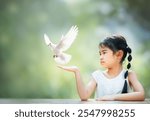 Asian girl holding White dove flying on green blur background  .freedom concept and international day of peace 