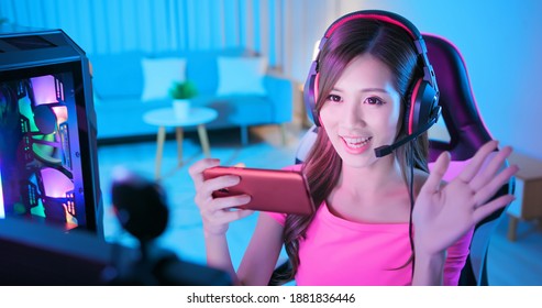 asian girl internet celebrity say hello to her fans in live stream and playing e sport mobile game on the smartphone at home - Shutterstock ID 1881836446