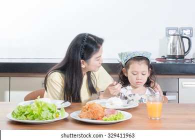 Asian Girl Kids With Expression Of Disgust Against Eat Rice While Mother Feed Breakfast
