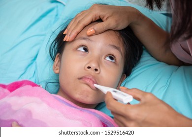 An Asian Girl Is Looking Her Mother And Hand Holding A Thermometer To The Mouth. May Have A Cough Until Sore Throat, Difficulty Swallowing, Colds, Flu Or Fever, Meet A Doctor At The Hospital