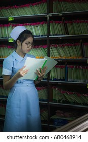 Asian Girl Nurse Reviewing Document