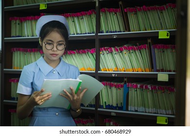 Asian Girl Nurse Reviewing Document