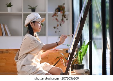 Asian Girl Painting Picture With Water Color In Art Class.