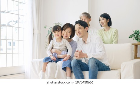 Asian Girl And Parents And Grandparents In The House. Three Generation Family.