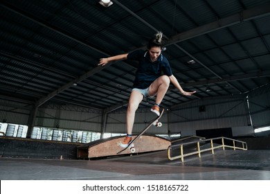 Asian girl perform jumping with her skateboard. - Powered by Shutterstock