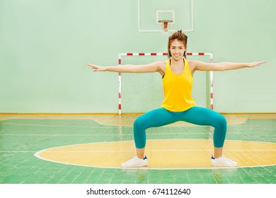 Asian Girl Performing Sumo Squat In Sports Hall