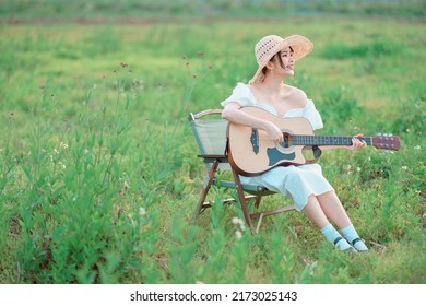 Asian girl playing guitar in camp - Shutterstock ID 2173025143