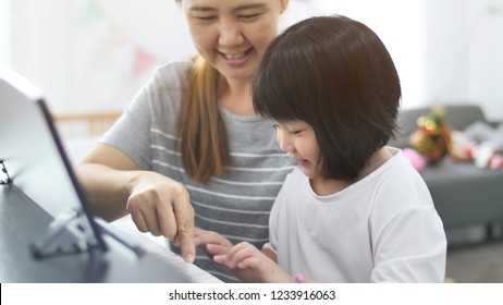 Asian Girl Playing Piano With Her Mother