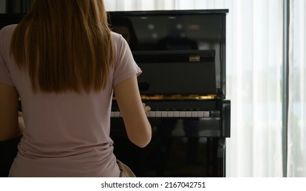 Asian Girl Playing The Piano On A Sunny Morning.