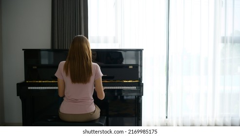 Asian Girl Playing The Piano On A Sunny Morning.