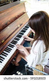 Asian Girl Playing Piano In Vertical