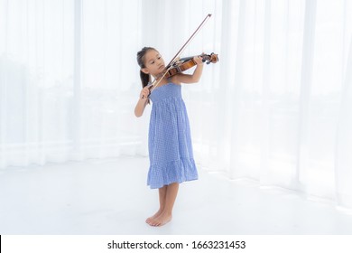 Asian Girl Are Playing Violin In The White Room.