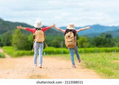 Asian Girl Raise Arms And Jumping On The Green Meadow Outdoors Adventure. People Kid Tourism  Traveling Education Nature Forest For Destination And Leisure Trips With Mountain.  Travel Vacations