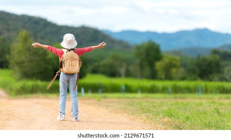 Asian Girl Raise Arms On Road With  Green Meadow Outdoors Adventure. People Kid Tourism  Traveling Education Nature Forest For Destination And Leisure Trips With Mountain. Travel Vacations And Life