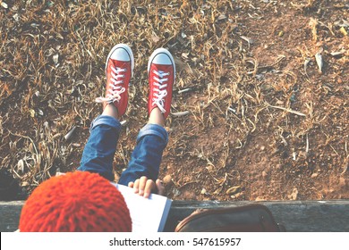 Asiatisches Mädchen, das in freier Zeit ein Buch über den Park liest. Weicher Fokus und Hipsterton