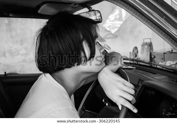 asian girl sad alone sitting in the old car,black\
and white tone