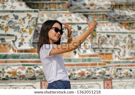 An Asian girl selfie herself with the Thai art wall