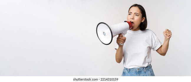 Asian Girl Shouting At Megaphone, Young Activist Protesting, Using Loud Speakerphone, Standing Over White Background