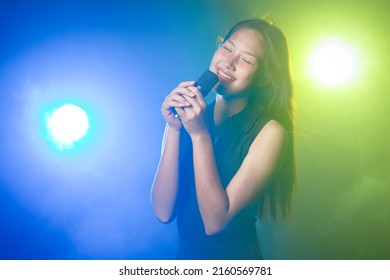 Asian Girl Sing A Song With Microphone.