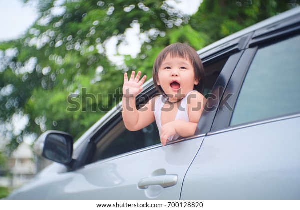 Asian girl Stay in the car, raise your hand\
to the mother or friend to go on\
vacations.