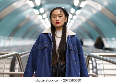 Asian Girl Street Fashion Portrait: Stylish Japanese Female Wearing Jeans Coat And Leather Beret On Escalator Ride To Underground Station. Casual Hipster Korean Woman. Urban Lifestyle And Modern Trend