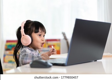 Asian girl student is happy learning online class at home and talking with friend and teacher in video, concept of online education and new normal of studying trend in the outbreak of corona virus. - Shutterstock ID 1779850457