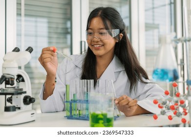 Asian girl student learning and doing chemical experiment in science class. Cute teenager female holding test tube while learning chemistry class in laboratory room.  - Powered by Shutterstock