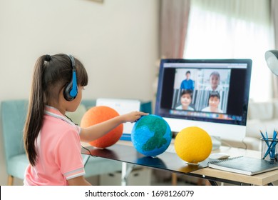 Asian Girl Student Live Learning Video Conference With Teacher And Other Classmates Giving Presentation, Showing Solar Model Project, Homeschooling And Distance Learning Online Education And Internet