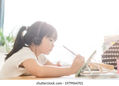 Asian Girl Student Online Learning At Home.study Online Video Call Zoom Teacher, Kid Girl Learn English Language Online With Tablet.