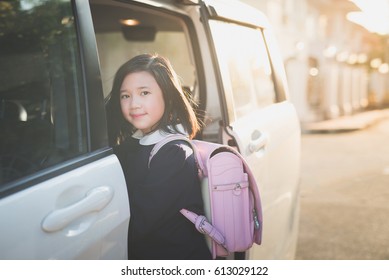 Asian Girl In Student Uniform Going To School By Car Under Sunlight