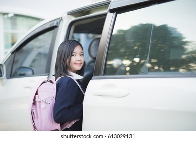 Asian Girl In Student Uniform Going To School By Car Under Sunlight