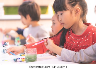 Asian Girl Students Is Drawing Water Painting In Kindergarten Art Classroom For Small Children Creativity Educational Concept.