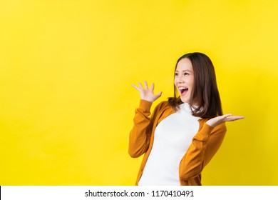 Asian girl is surprised she is excited.Yellow background studio - Shutterstock ID 1170410491