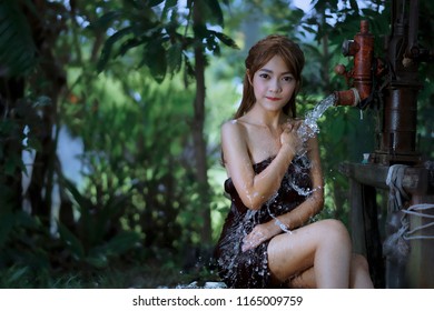  Asian Girl Take A Shower Outdoor From A Traditional Groundwater Pump,countryside Thailand.                              