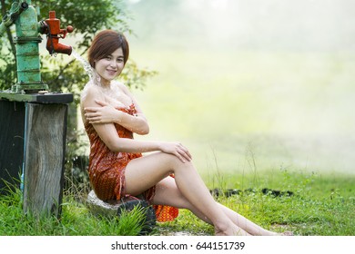 Asian Girl Take A Shower Outdoor From A Traditional Groundwater Pump,countryside Thailand.