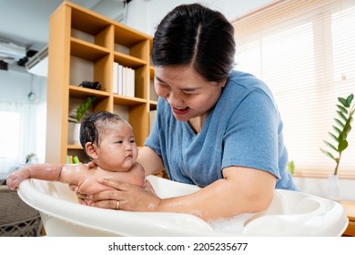 Asian Girl Taking A Shower He Bathed In A Bubble Bath. A Single Mother Gently Bathes Her Newborn Daughter, And Her Daughter's Face And Body Are Filled With Bubbles.