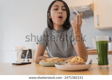 Asian Girl  eating Thai food in kitchen counter Home delivery food feeling happy.