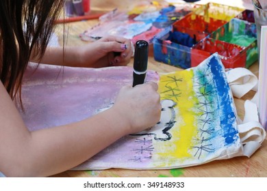 asian girl use brush paint picture on fabric bag ,Little girl and boy painting picture by brush on table in kindergarten, artist tool and imagination ,art school.