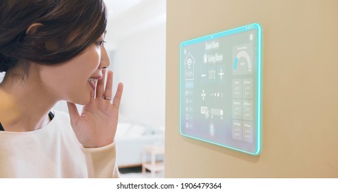 Asian girl use smart home app to turn on air condition by voice contorl through transparent futuristic tablet - Powered by Shutterstock