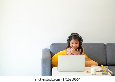 Asian girl using desktop computer for online study homeschooling during home quarantine. homeschooling, online study, home quarantine, online learning, corona virus or education technology concept