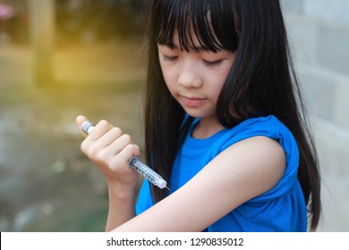 An Asian Girl Using Insulin Pen.Self Insulin Injection.Diabetes In Children.